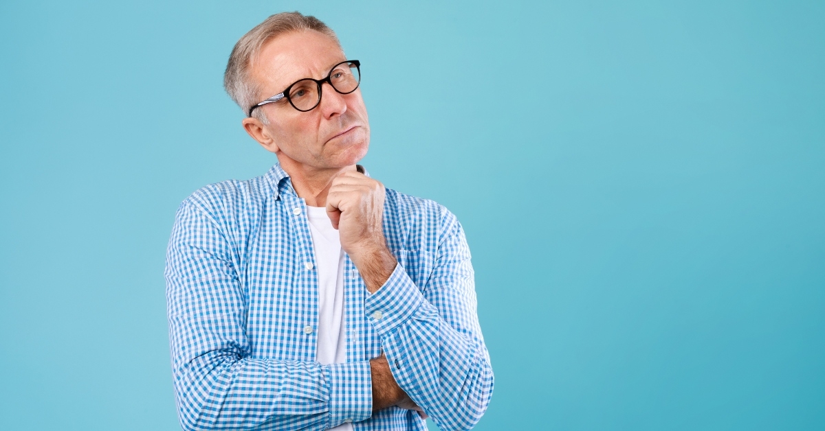 pensive mature man looking up at studio