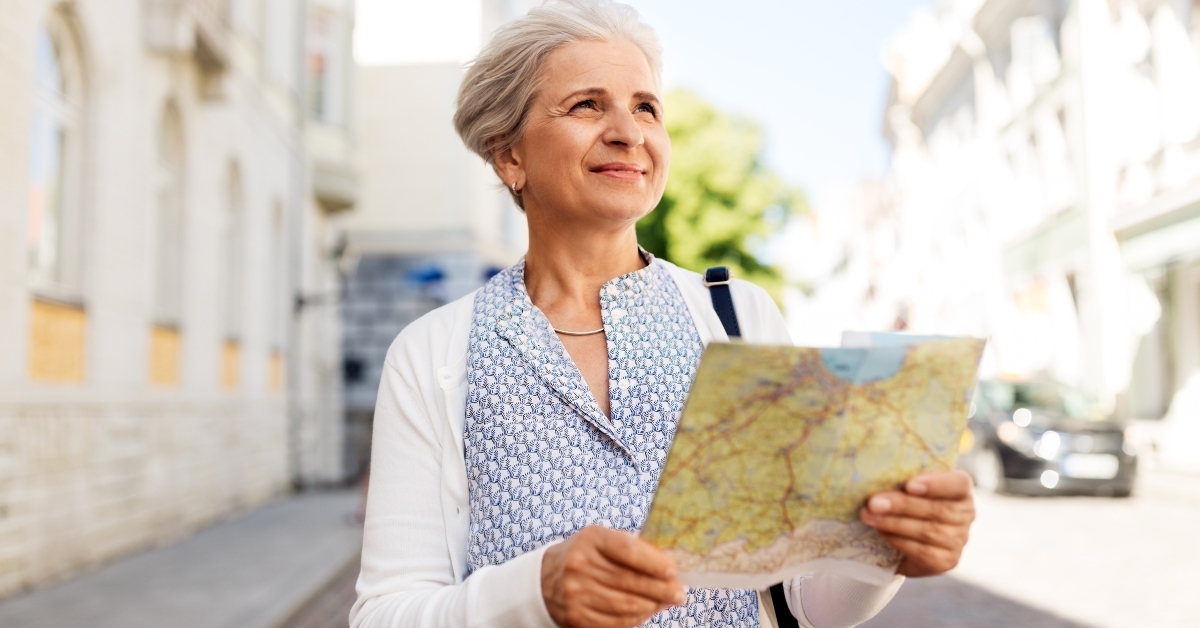 senior female tourist with map on city street