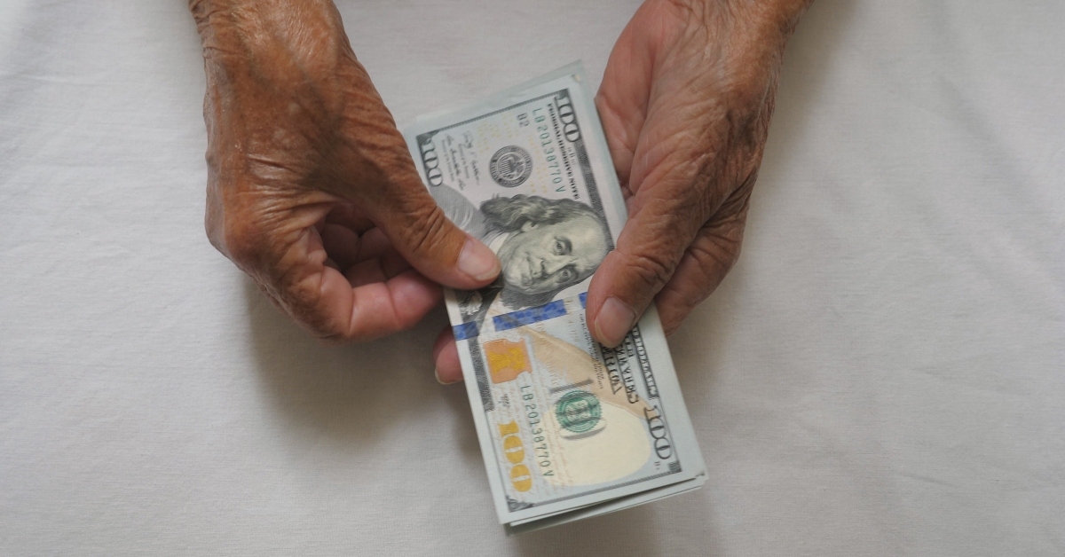 wrinkled female hands holds cash