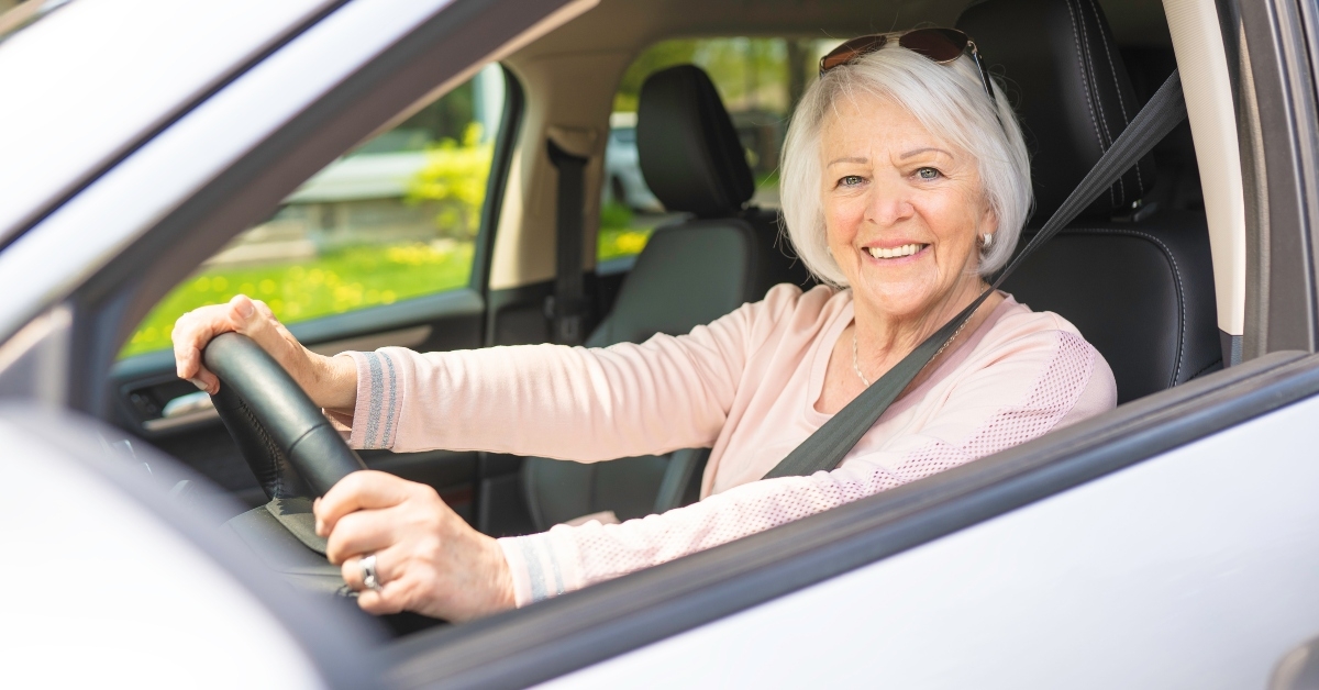 happy and smiling senior woman in white car