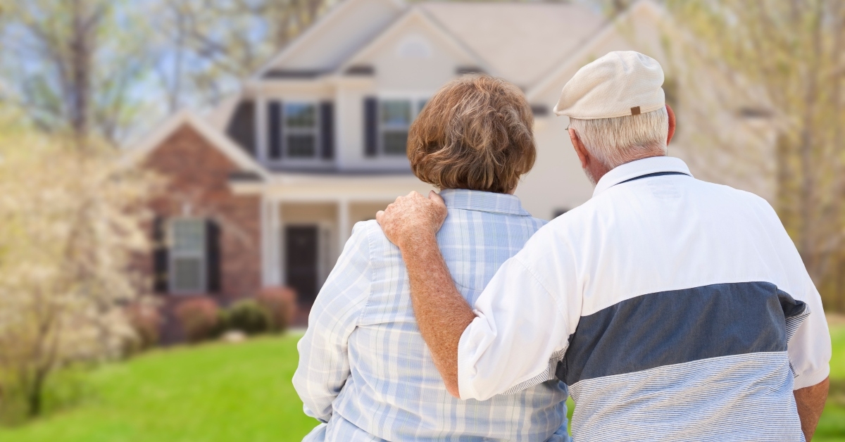 Older couple in front of house