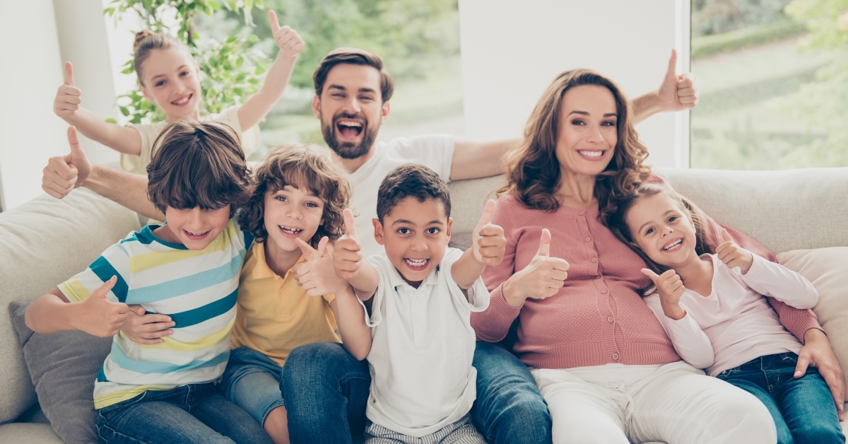 cheerful big family showing thumbs up