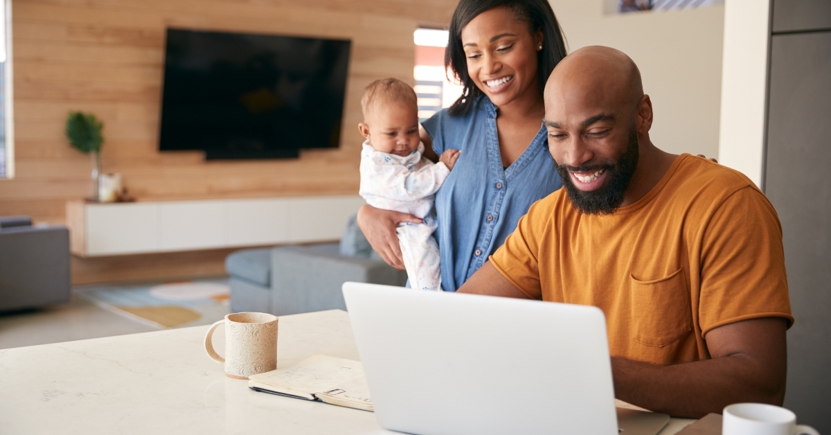 family with baby daughter using laptop to check finances