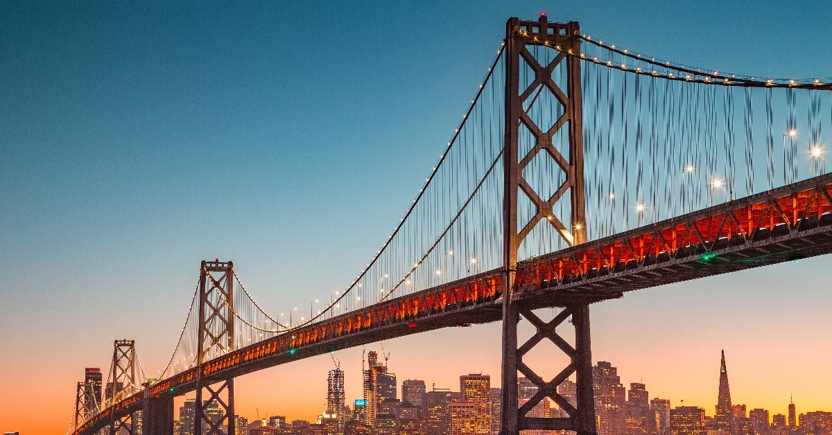 oakland bridge on water surrounding san francisco skyscrapers