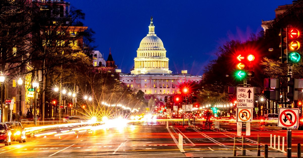 street lights illuminate traffic with the White House buildings dome visible in the background