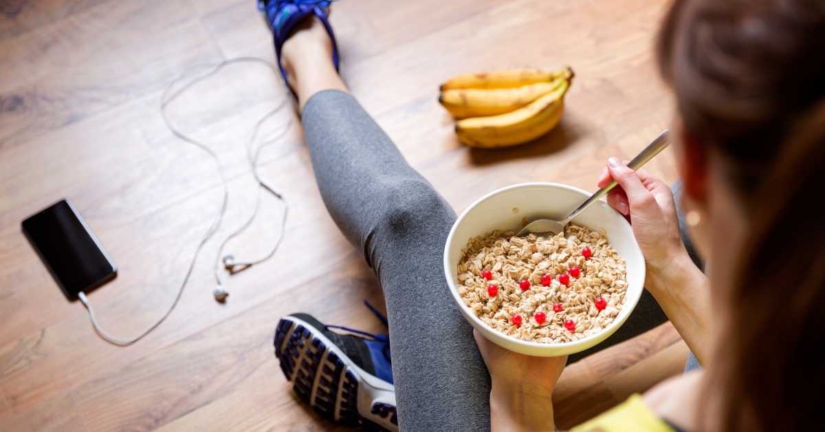young girl eating an oatmeal with berries after a workout