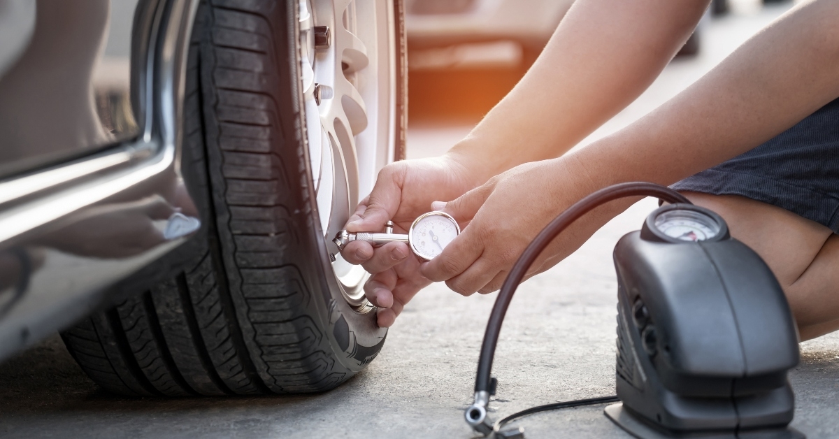 man uses tire gauge analog checking air pressure of wheel car