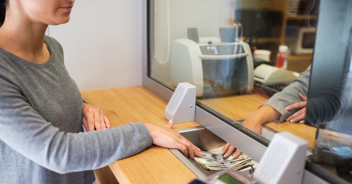 clerk giving cash money to customer at bank office