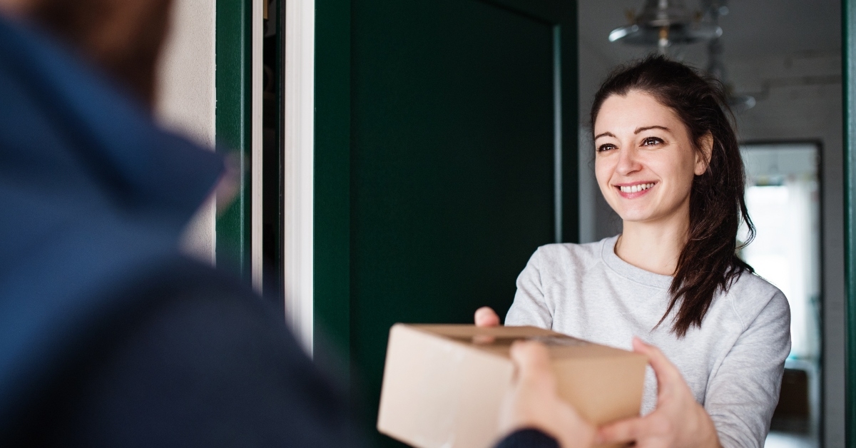 woman receiving parcel from delivery man at the door