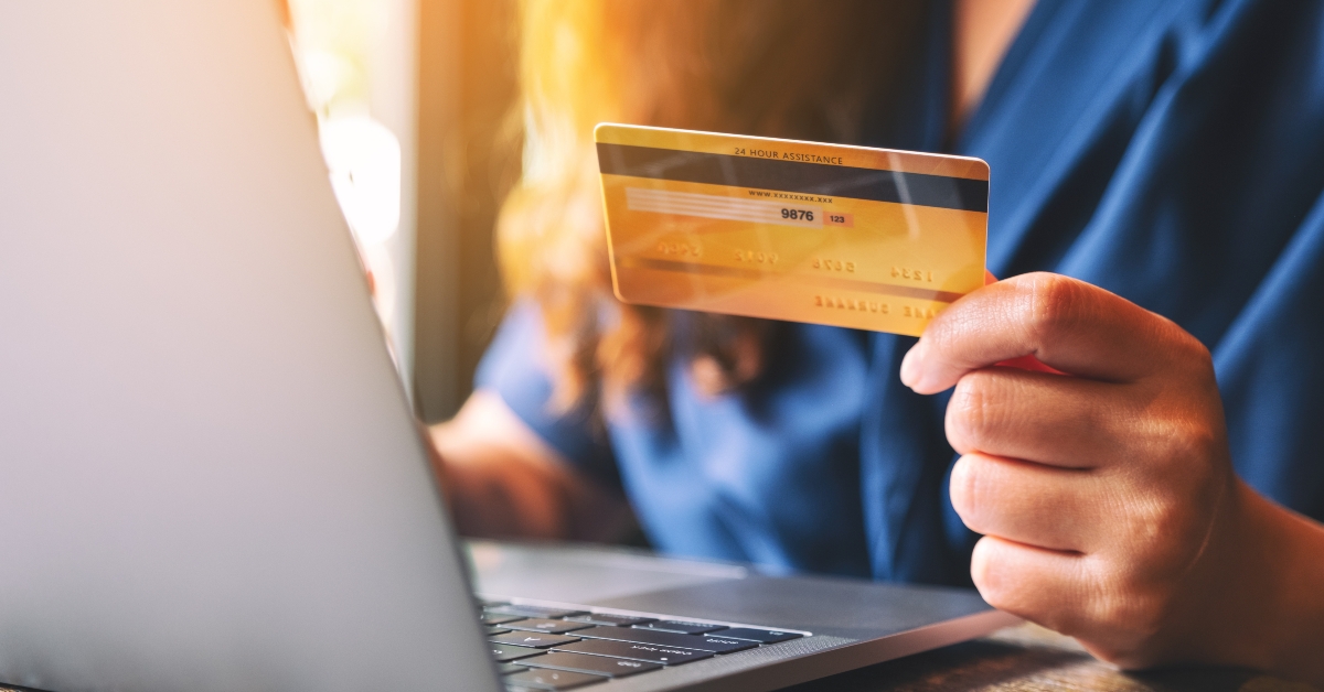 businesswoman holding credit card while using laptop