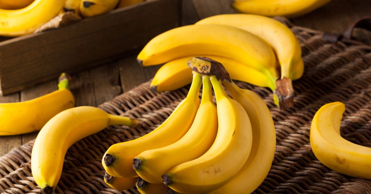 yellow colored fresh raw organic bananas on plank for sale at store