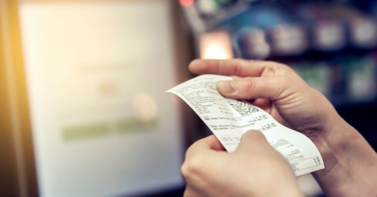 woman reviewing grocery receipt 