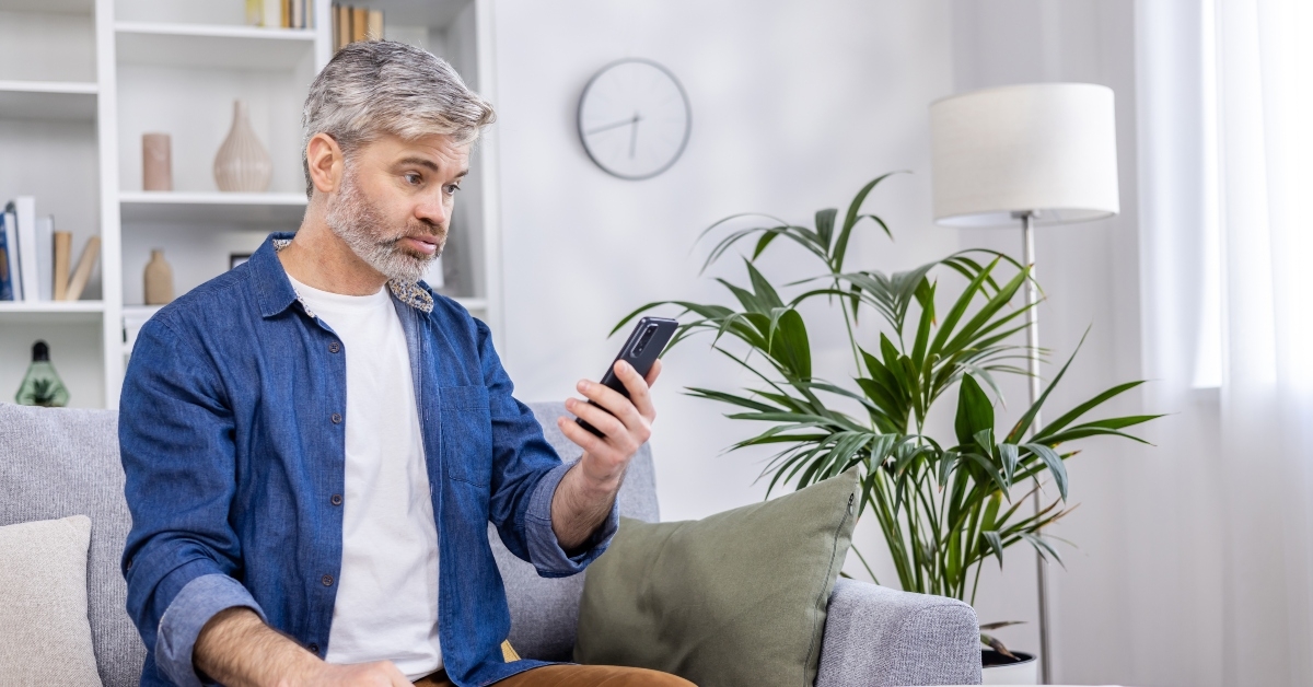 adult man upset reading bad news online from phone