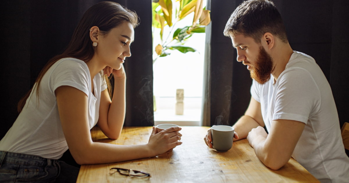couple sitting at table drinking coffee 