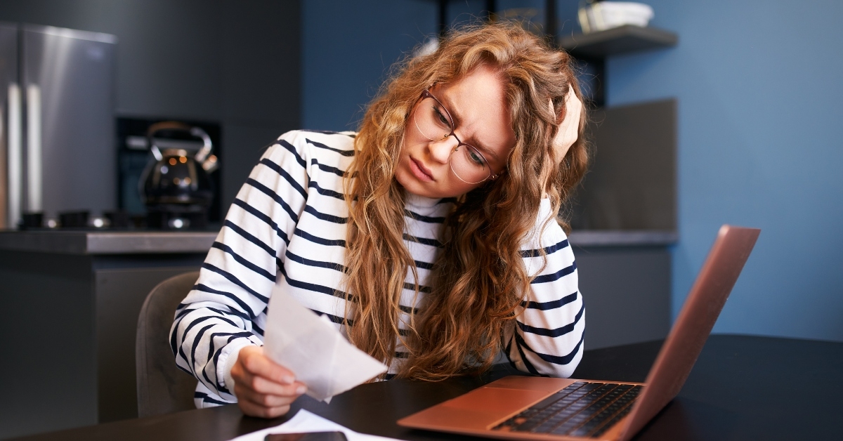unhappy woman calculates expenses on bills