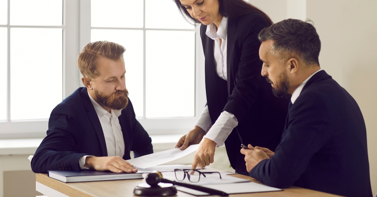 diverse lawyers sit at desk at meeting