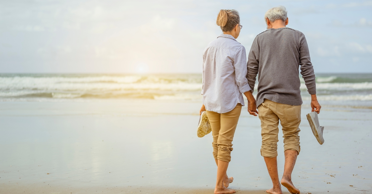 senior couple walking on the beach holding hands