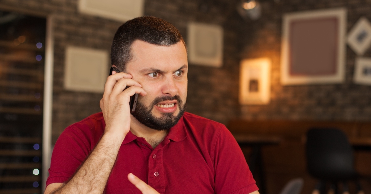 young angry man talking on the phone