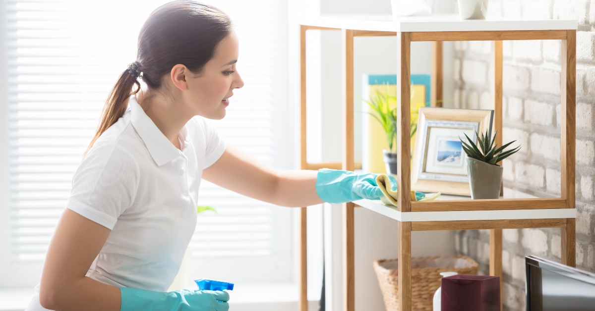 young woman cleaning the shelf in house