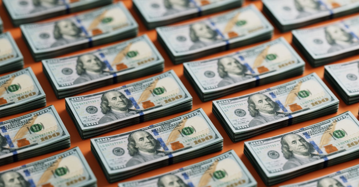 stack of one hundred dollar bills arranged in rows