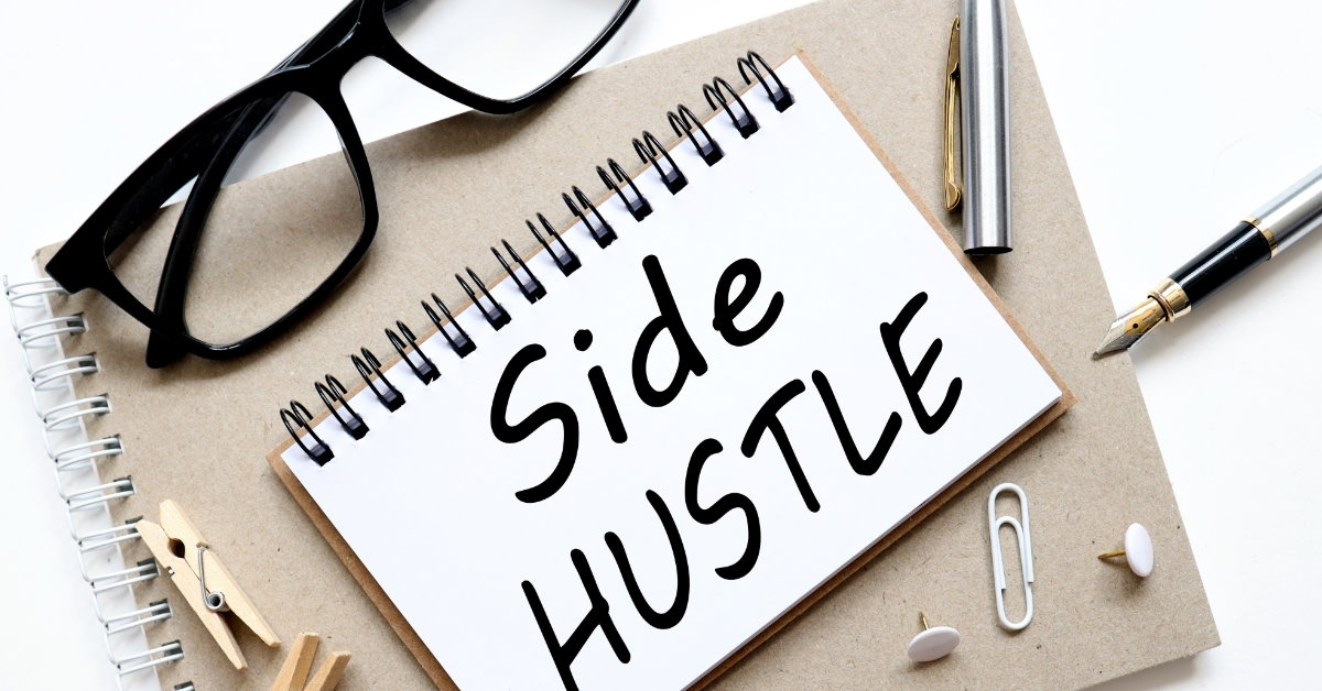 white paper with side hustle written over it at white table with  pen glasses and clippers