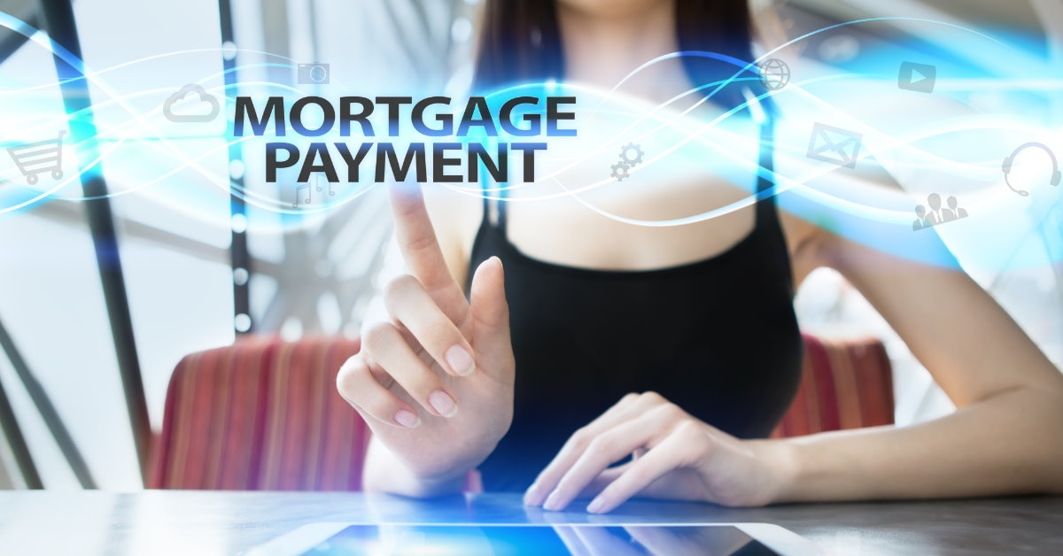 woman sitting at table using laptop selecting mortgage payment on virtual screen