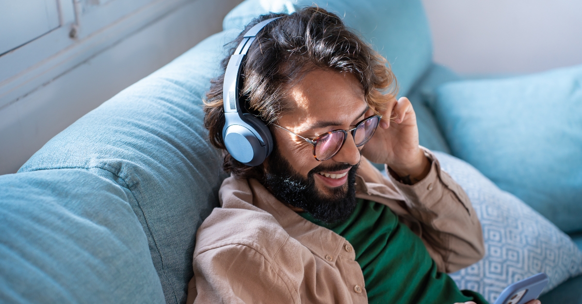 young man wearing headphones listens to mobile music