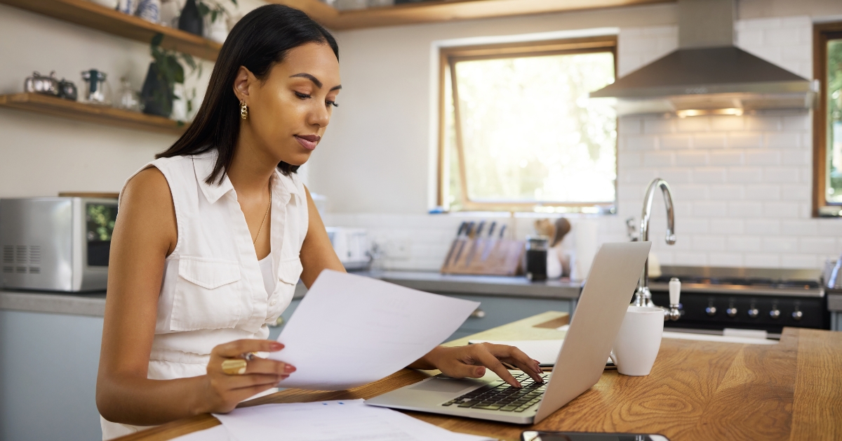 businesswoman in kitchen with financial research