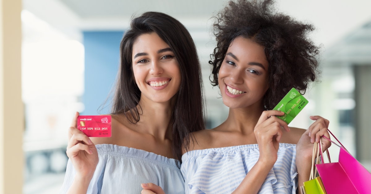 beautiful happy women inside mall holding cards 
