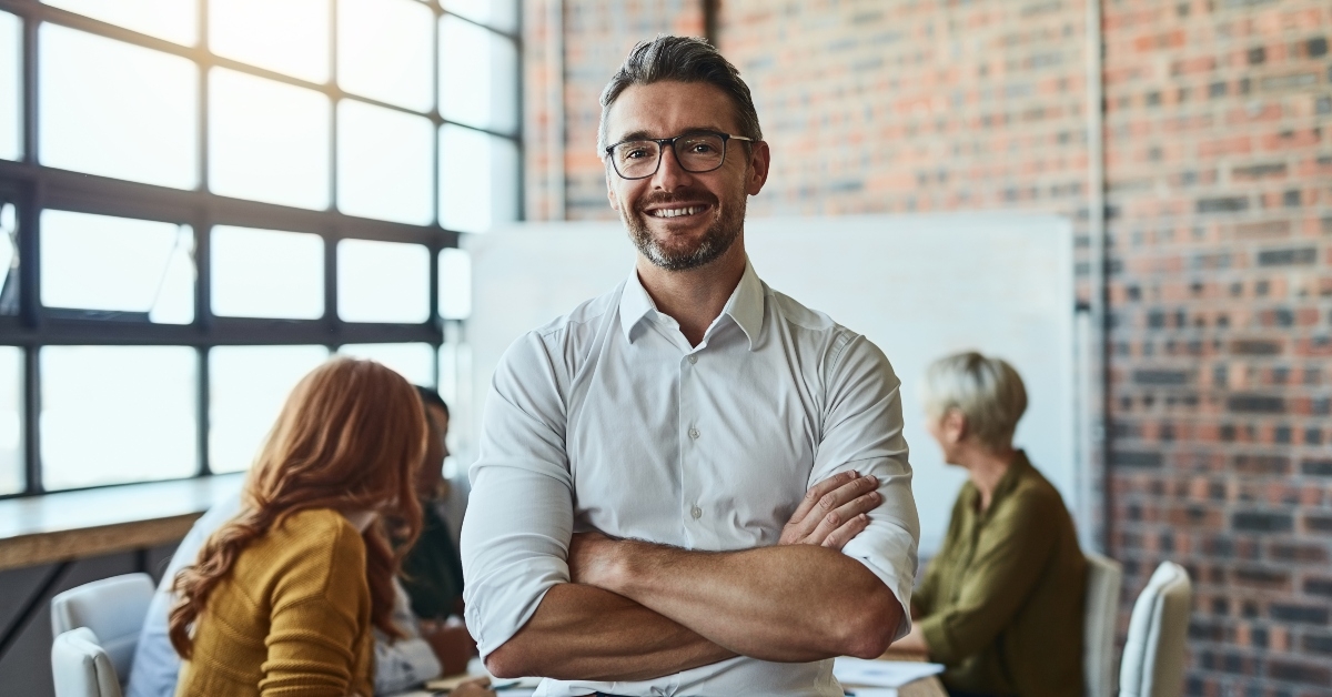 businessman standing in the office with his arms folder