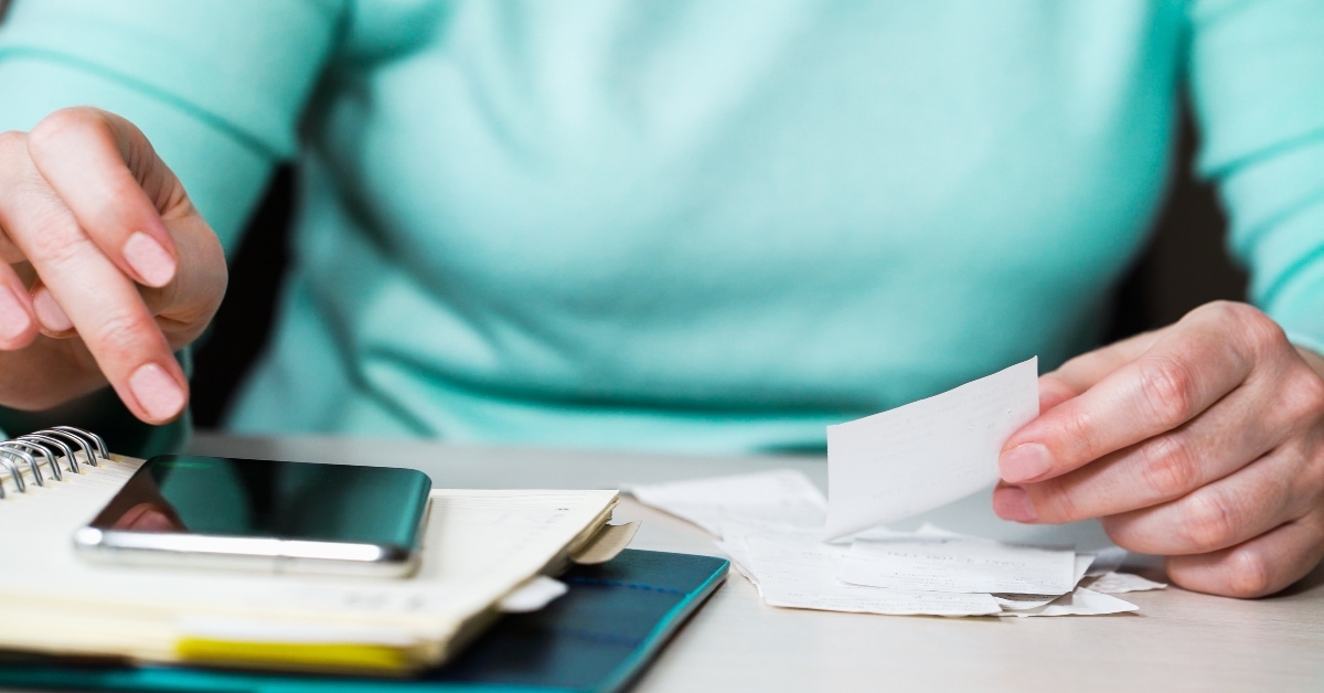hands checking bills and writing down expenses