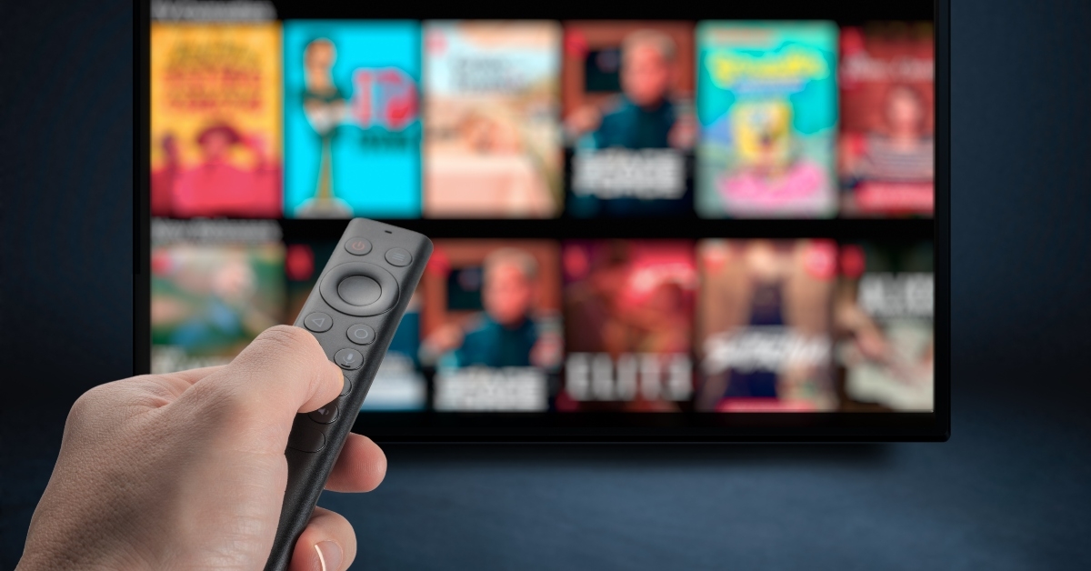 male hand holding TV remote control