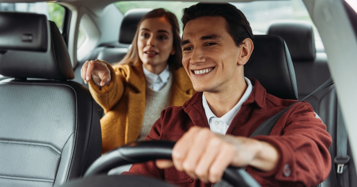 taxi driver with woman passenger pointing on road