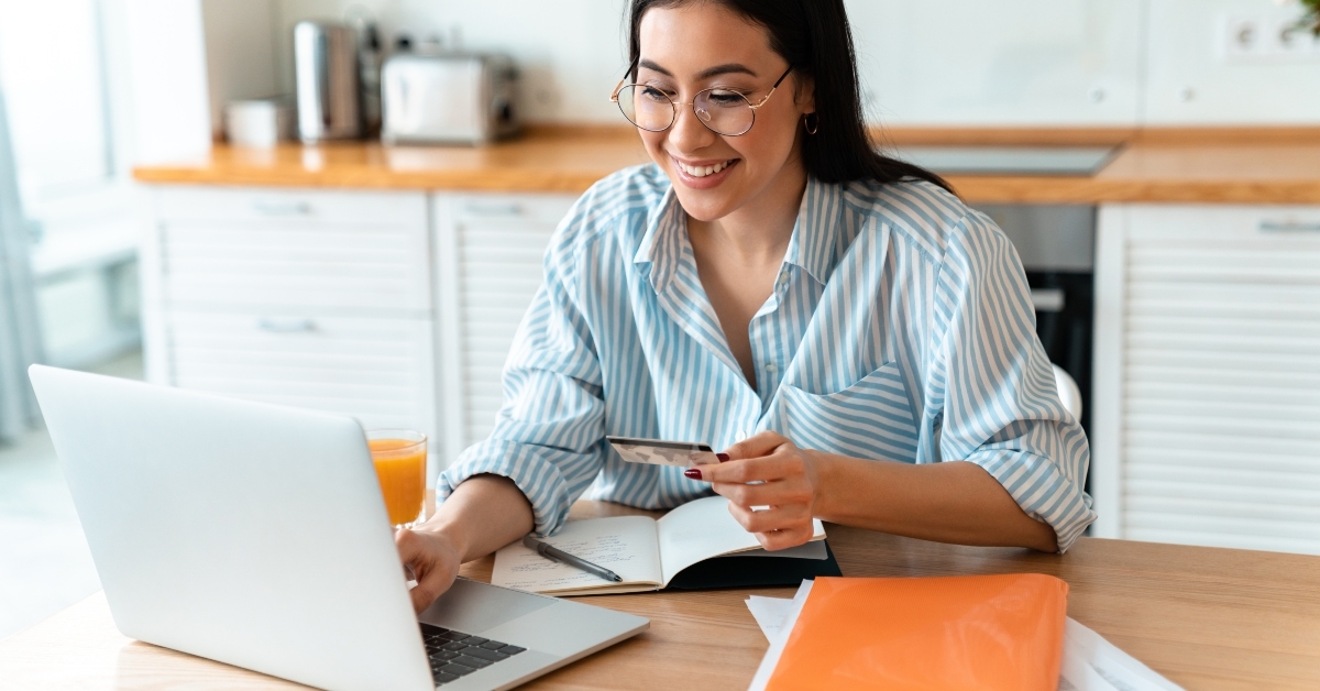 woman using laptop computer holding credit card