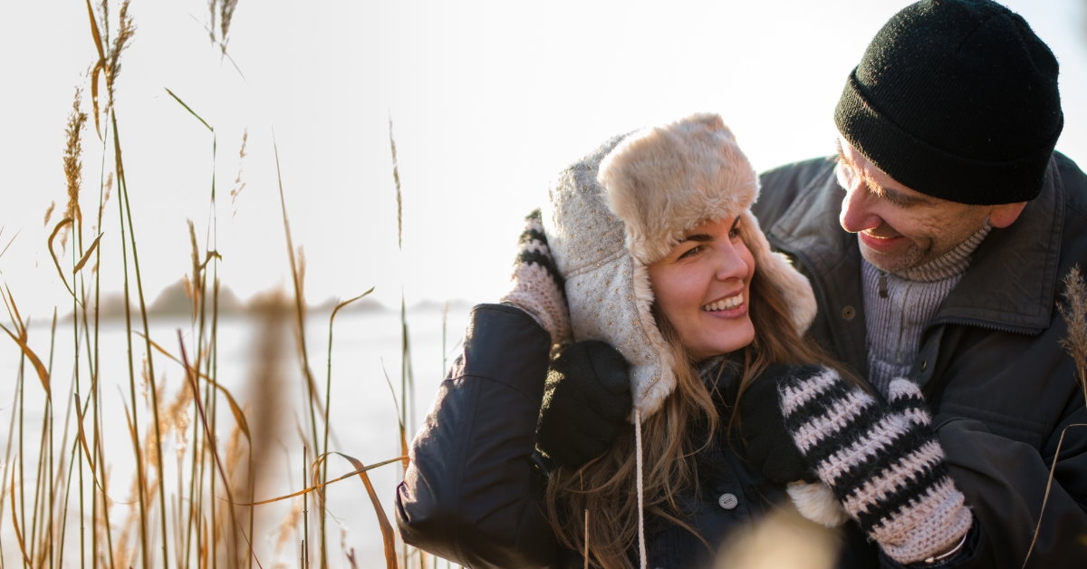 beautiful couple wearing winter gear enjoying each others company outdoors during day time