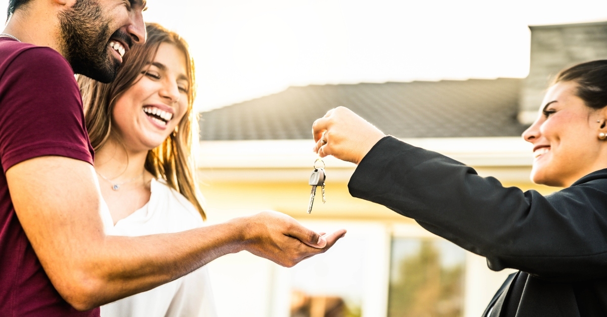 couple receiving keys from realtor