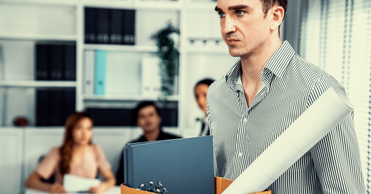 disappointed employee packing his belongings after being fired 