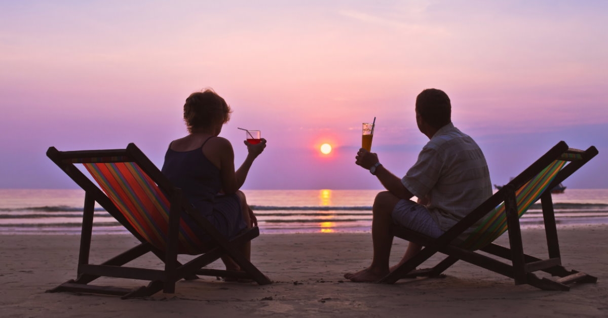 senior couple enjoying drinks at the beach