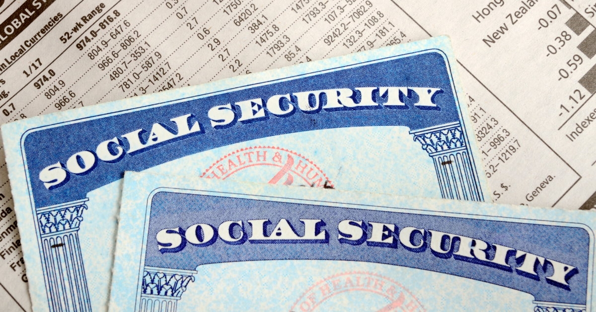 social security cards placed on top of a stock market paper