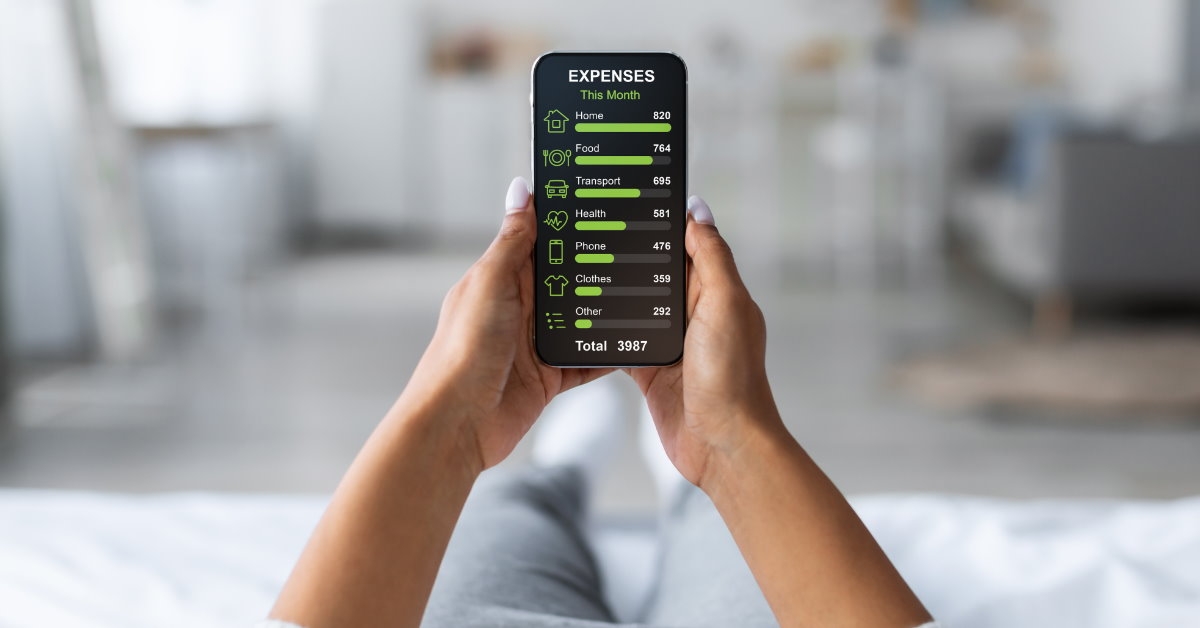 woman sitting at home using smartphone to check expenses for the month on app