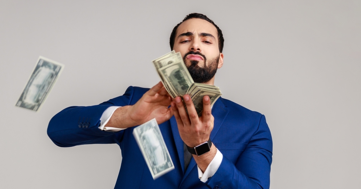 bearded man scattering dollars with arrogant grimace