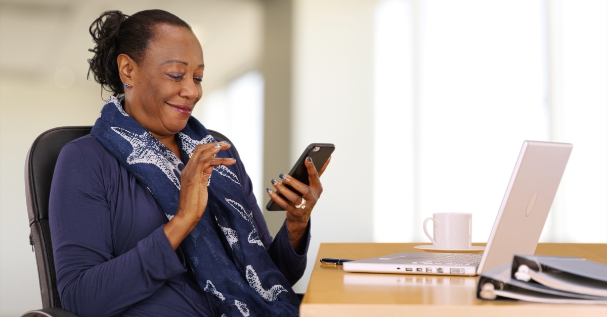 businesswoman uses her mobile phone at her desk
