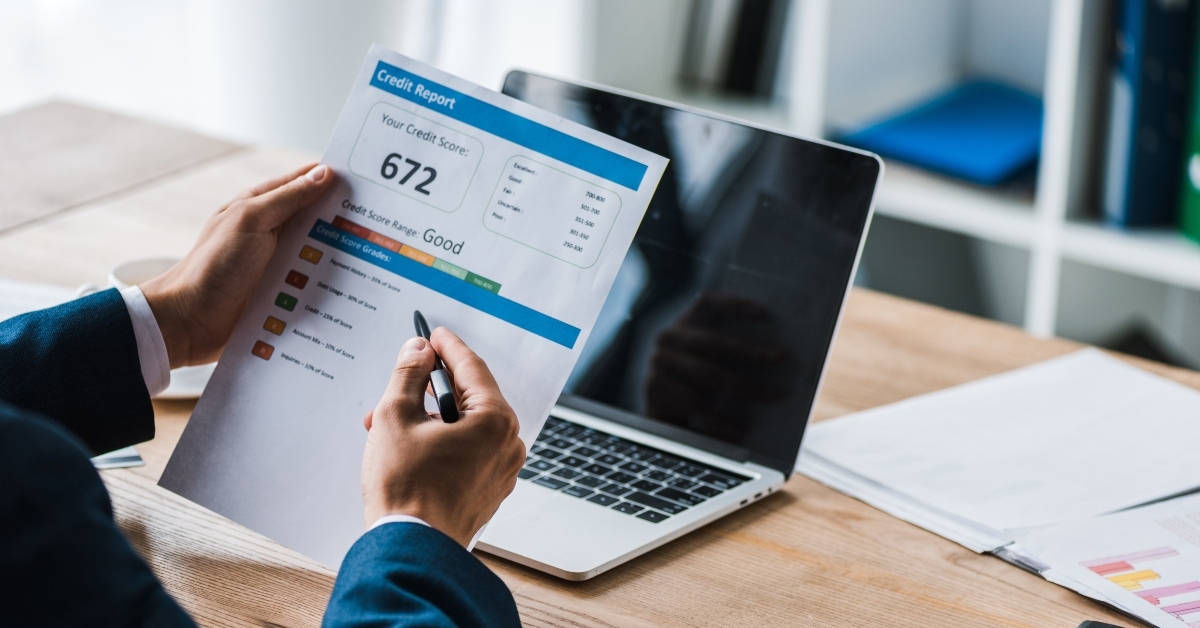 man holding pen near paper with credit report letter