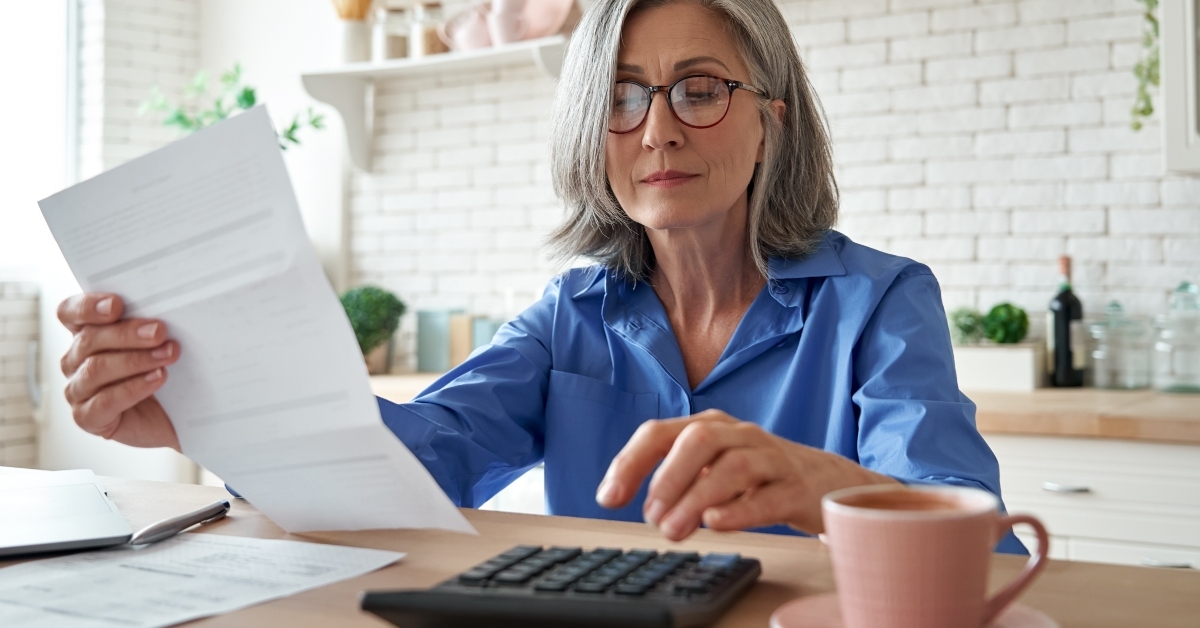 senior businesswoman holding paper bill