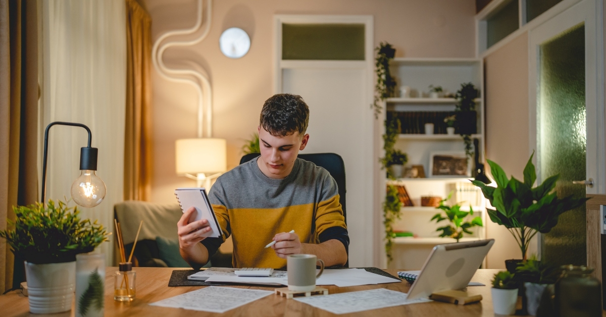 teenage student studies at home at the table 