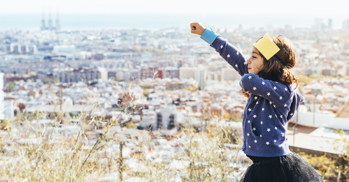 little girl wearing paper crown holding fist in the air