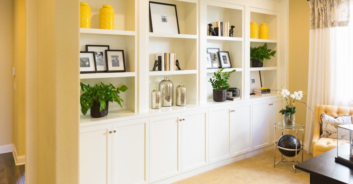 white cabinets and shelves inside living room full of decoration pieces