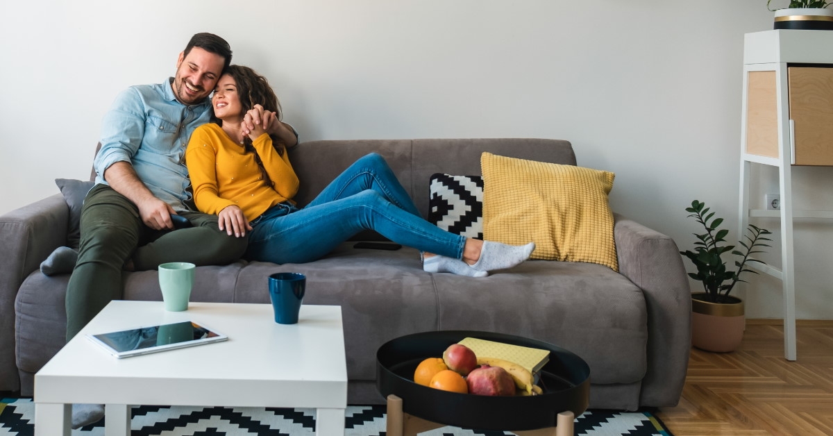 couple relaxing together on -their sofa at living room
