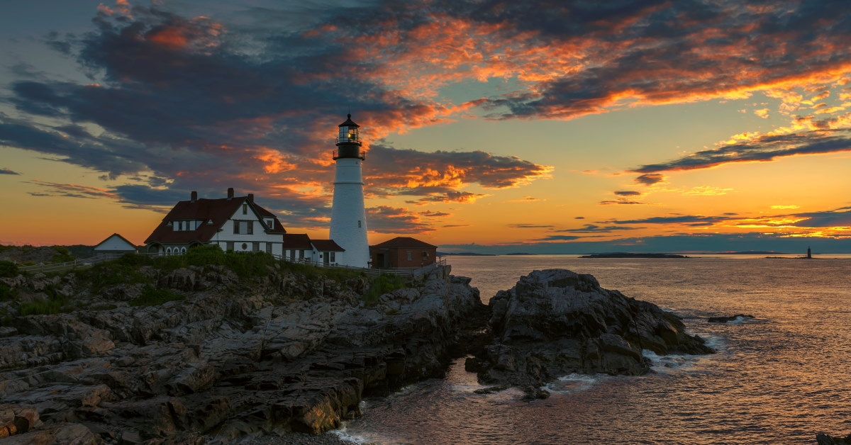 portland lighthouse in front of sea with calm water in maine