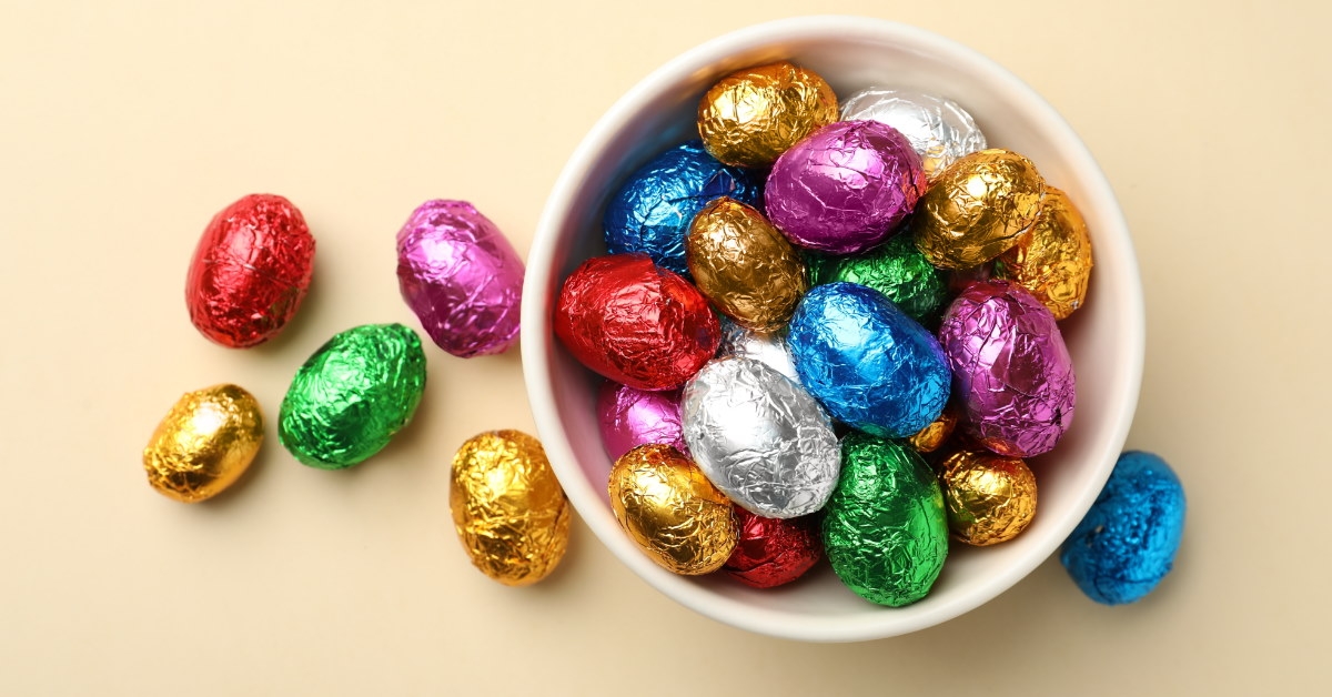 white bowl with chocolate eggs in colorful foils 